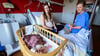 Im Klinikum Lüneburg werden Verena Ahrens und ihre wenige Tage alte Tochter von Hebamme Franziska Pfeil (r) betreut. Pfeil hat die erste Geburt im neu eröffneten hebammengeleiteten Kreißsaal im Klinikum Lüneburg betreut.
