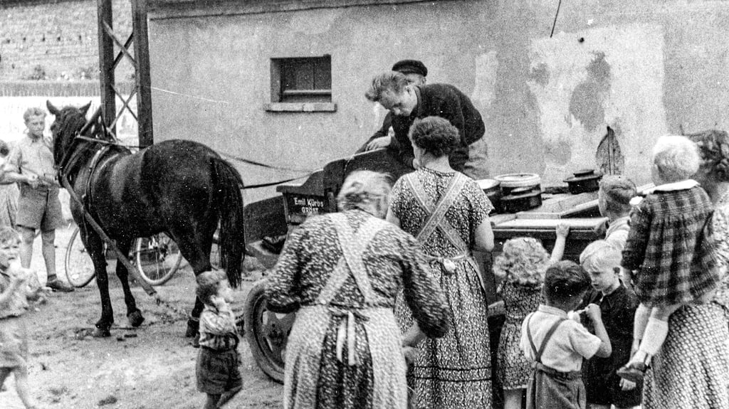 Das Foto (entstanden um 1960) zeigt, wie Bäcker Kürbs junior aus Gröst neben dem Bornhaus seine Ware verkauft.