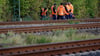 Bahn-Mitarbeiter stehen am Rand der Strecke Köln-Düsseldorf.