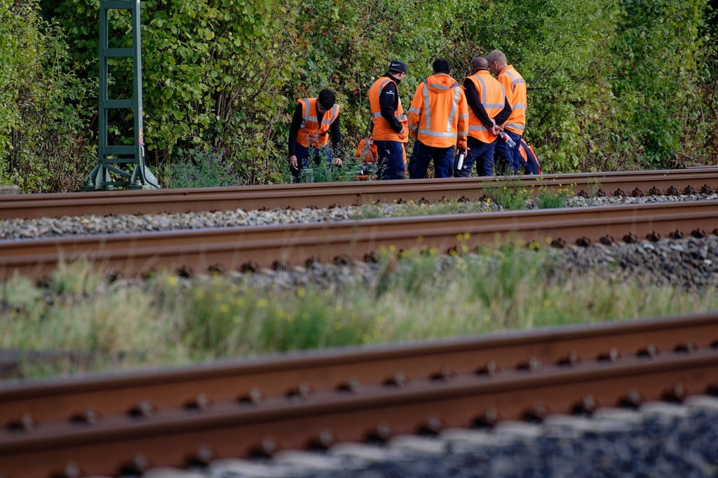 Bahn-Mitarbeiter stehen am Rand der Strecke Köln-Düsseldorf.