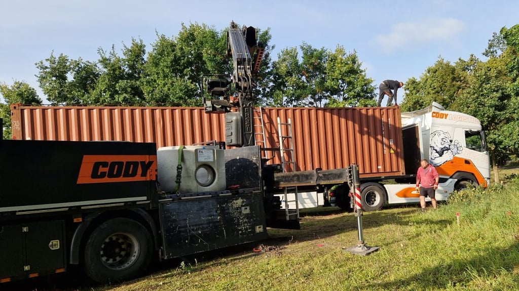 Anlieferung vor Ort: Die ersten Container für den neuen Schießstand des Schützenvereins Velsdorf treffen ein. Mit schwerem Gerät beginnt der Aufbau an alter Stelle.