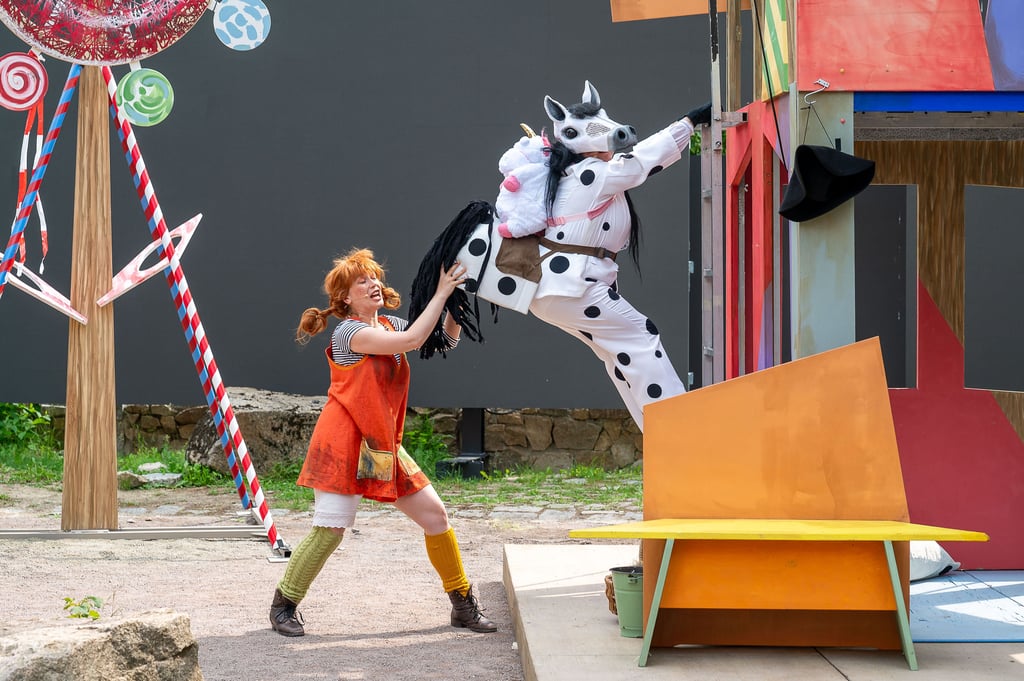 Kraftprotz mit Zöpfen: Pippi Langstrumpf stemmt ihr Pferd – zum Staunen des Publikums.