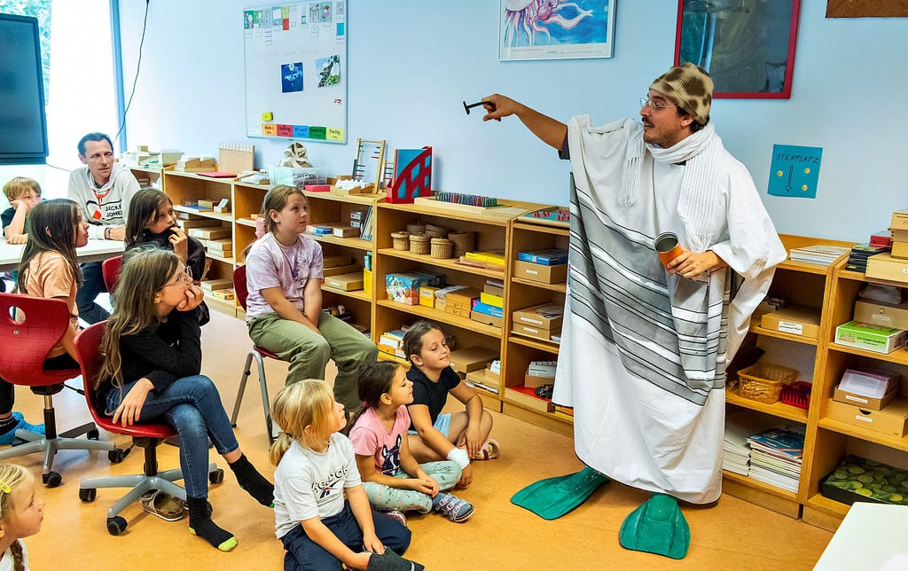 Schauspieler Jean-Baptiste Vizmathy übernimmt im Klassenzimmerstück „Viele Grüße, Deine Giraffe“ alle Rollen und verwandelt sich in mehrere Tiere, so auch in eine Giraffe, die sich als Pinguin verkleidet.
