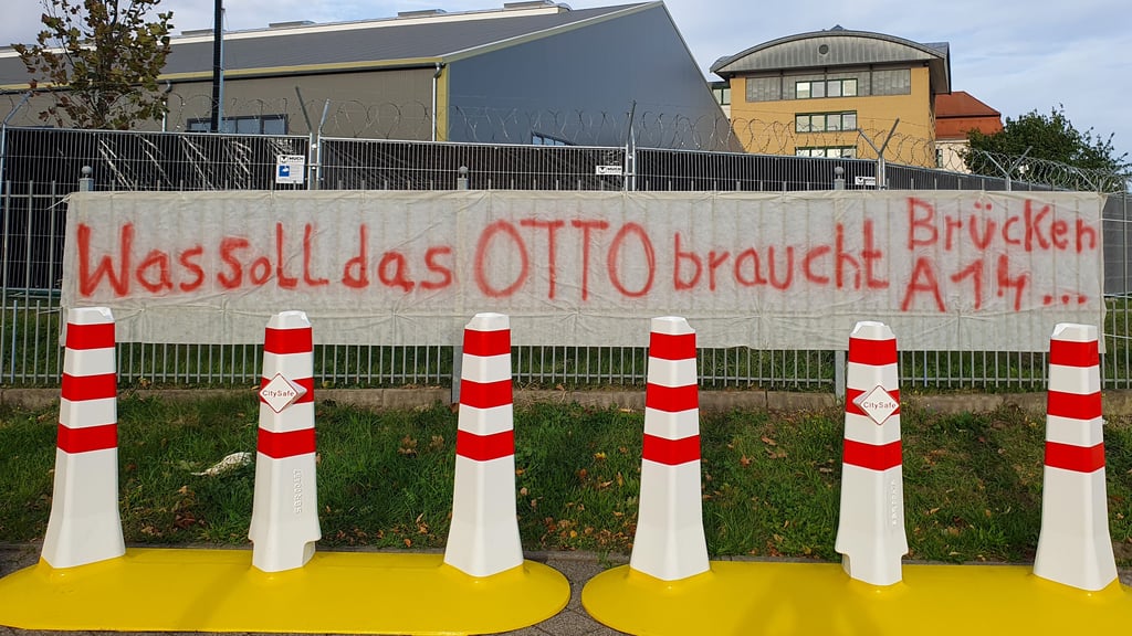 Ein Protestplakat hing am Donnerstag (25. September 2025) kurz am Zaun des provisorischen Gerichtsgebäudes für den Prozess gegen den Weihnachtsmarkt-Attentäter.