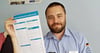 Constantin Chmelka, Ortsverbandschef des Technischen Hilfswerks Salzwedel, hält eine Checkliste des Bundesamtes für Katastrophenschutz  zum Selbstschutz für Bürger in die Höhe.