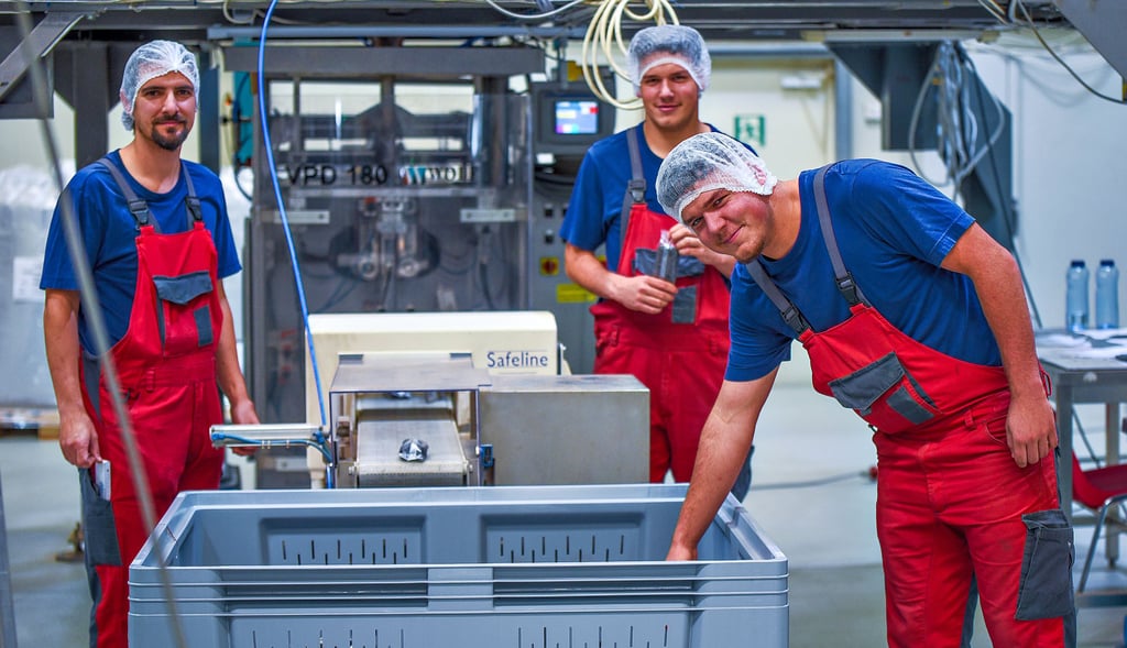 Die Azubis Fabian Kopp (vorne) und Leon Kopp (hinten) mit Ausbilder Sebastian Krobitzsch (links) im Produktionsbetrieb.