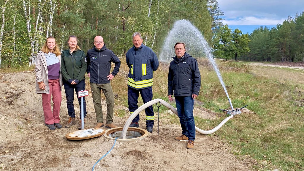 Der Beweis ist erbracht: Der Brunnen und die Technik funktionieren. Davon überzeugten sich Helen Rosenhahn von der Baufirma, Revierförsterin Katalin Wiese-Brattig, Christian Sürie von der DBU, der stellvertretende Stadtwehrleiter Thomas Riedel und Jessens Bürgermeister Michael Jahn (alle von links).