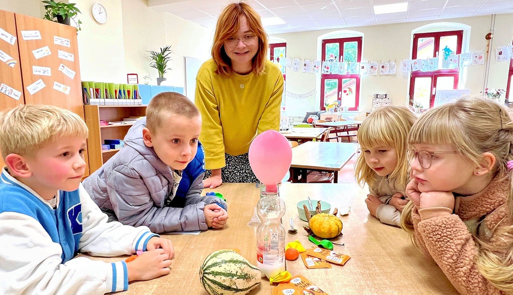 Lehrerin Stefanie Rathmann zeigt Vincent (von links), Tommy, Meghan und Lotta, wie sich ein Luftballon ohne Pusten aufbläht.
