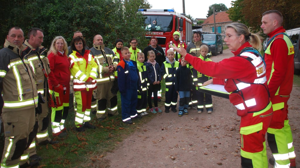 Die Zugführerein Constanze Anton (rechts) erläutert den Mitgliedern der Feuerwehr Seehausen die Aufgaben des ASB-Rettungshundezuges.