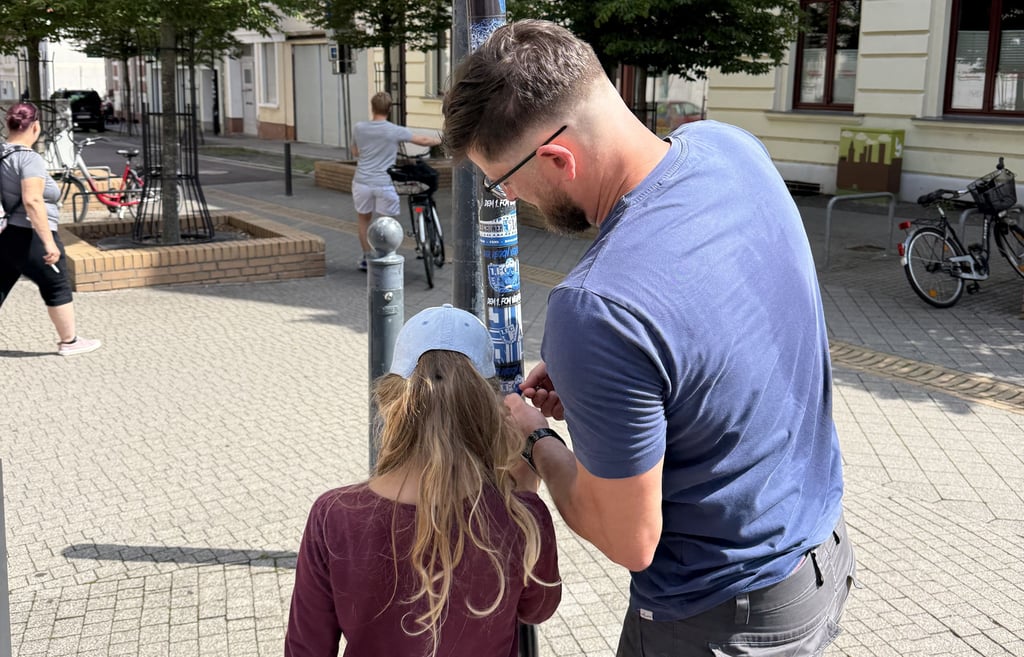 Bei den Putzaktionen der Fraktion "Wir für Burg" werden auch Aufkleber entfernt.