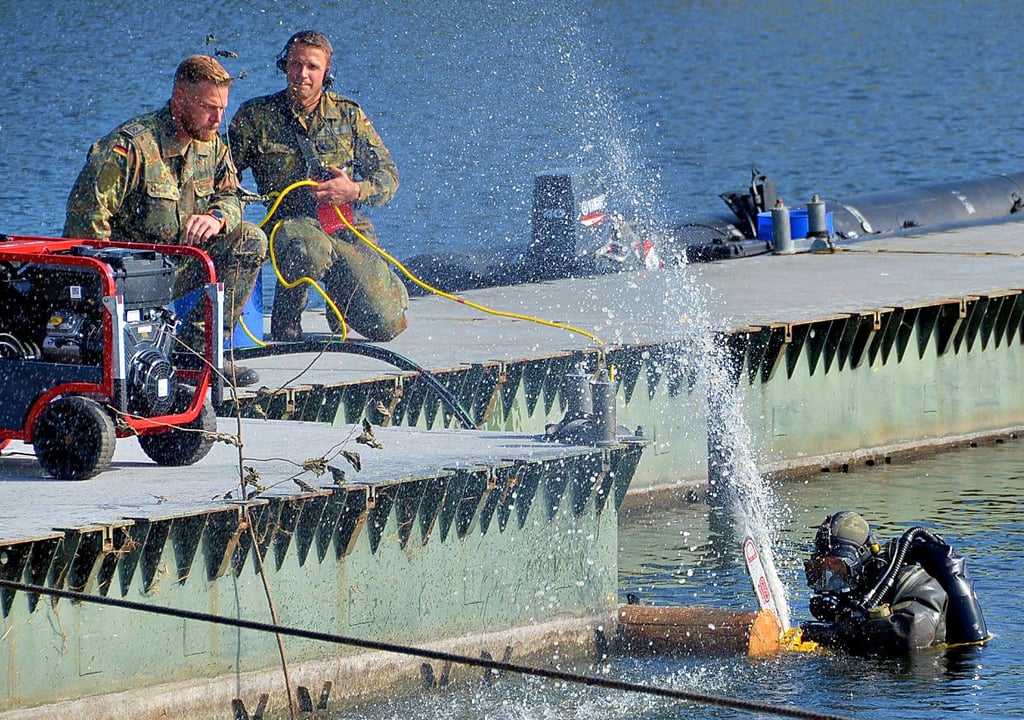 Ein Pioniertaucher demonstriert in Nitzow den Umgang mit der Unterwasser-Kettensäge. Diese wird mittels Hydraulik angetrieben.