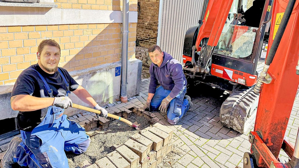 In der Friedrichstraße in Hecklingen verlegen die Mitarbeiter der Firma SSS Energietechnik aus Aschersleben, Alexander Kunze (l.) und Mike Müller, das neue Stromkabel.