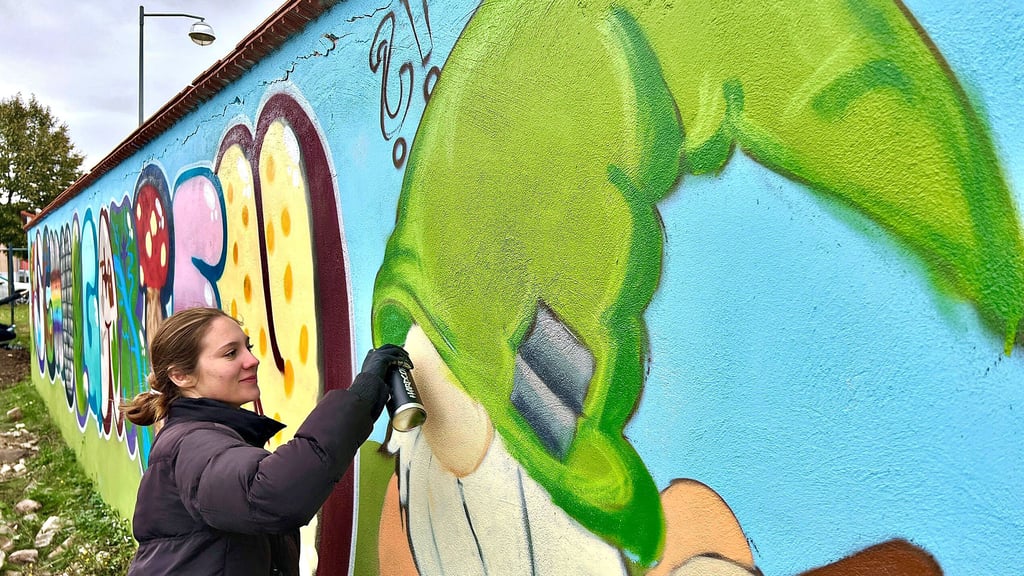 Zehntklässlerin Victoria Drvinco arbeitet am Feinschliff des Gartenzwergs, der Teil des Graffiti-Kunstwerks an der Schulgartenwand in Könnern ist.