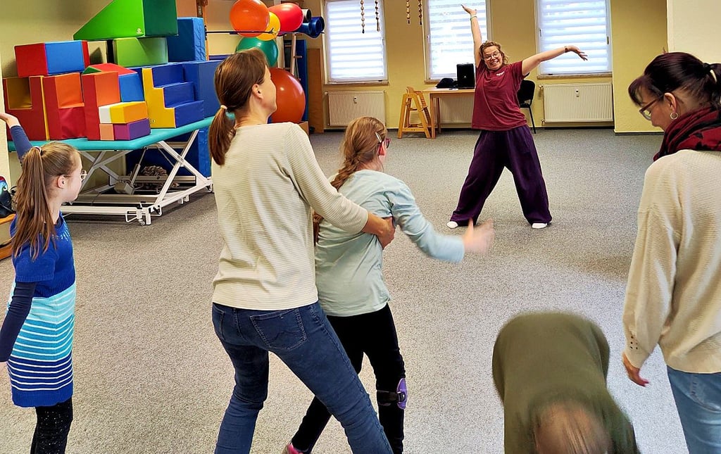 Melanie Stittrich (Hintergrund) gibt einen Tanzkurs für Kinder von sechs bis zwölf Jahren mit Down-Syndrom.