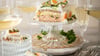 Schicht für Schicht zur Brottorte: Mit Eiersalat, Wiener Würstchen und Obazda-Füllung sorgt die viereckige Torte für Bewunderung.