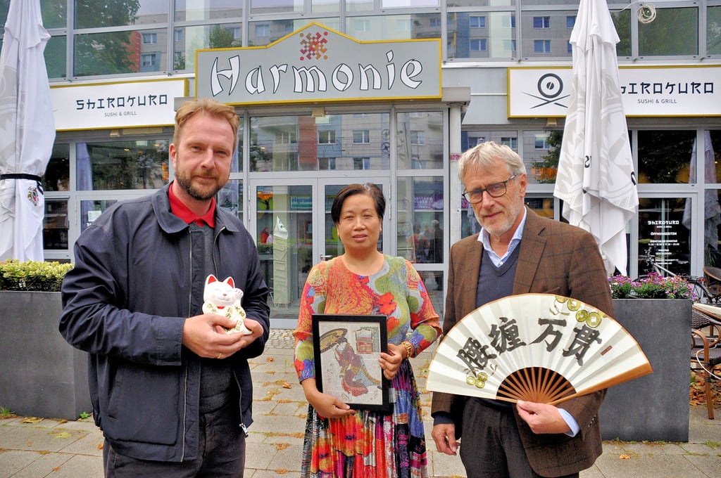 Die Deutsch-Chinesische Gesellschaft bereitet mit Glückskatzen, Kunst und Fächer ein Fest für den 2. Oktober vor. Neben anderen wirken Karsten Steinmetz (l.), Xiaomei Cai als Inhaberin des Veranstaltungsorts und Rainer Nitsche mit.