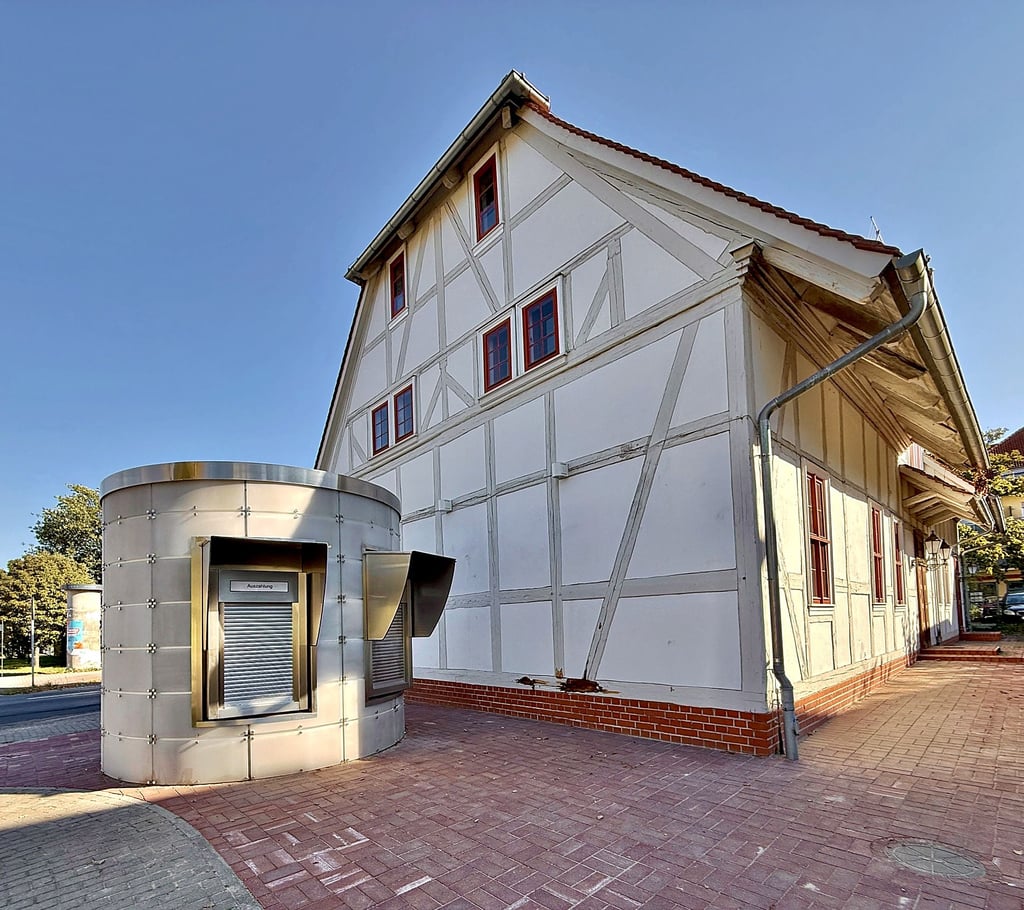 Was für ein Kontrast: Vor dem historischen Pächterhaus, dem ältesten Haus Ziebigks, steht seit August ein Geldautomaten-Häuschen. Nun hat die Sparkasse bekanntgegeben, warum der Automat versetzt wurde.