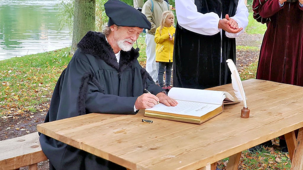 Rainer Böge trägt sich in das Goldene Buch von Allstedt ein.