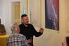 Marcus Haberkorn spricht mit einem Ausstellungsbesucher im Filmmuseum Ballenstedt über seine Bilder.