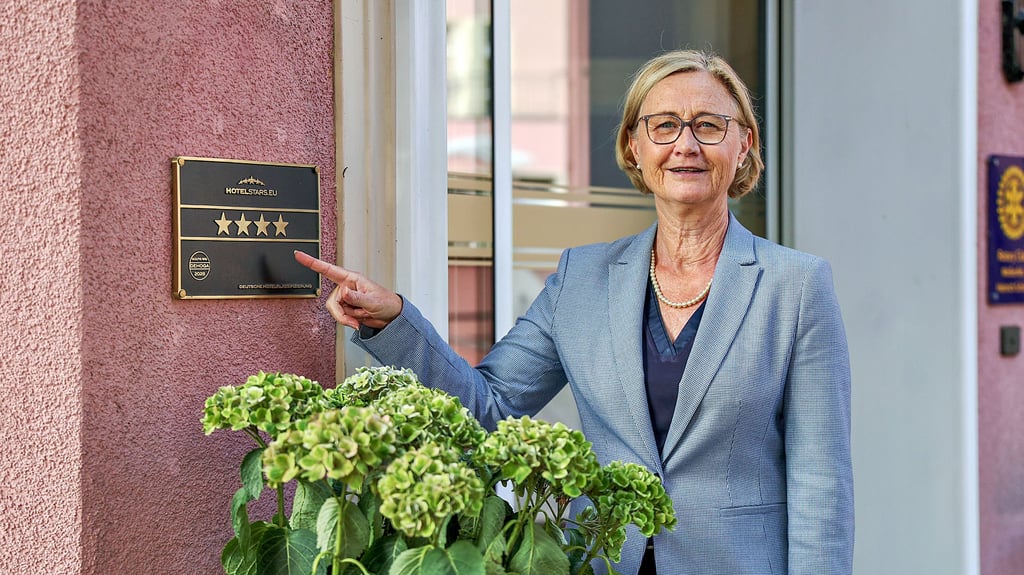 Melanie Albrecht mit dem Vier-Sterne-Schild an ihrem Hotel