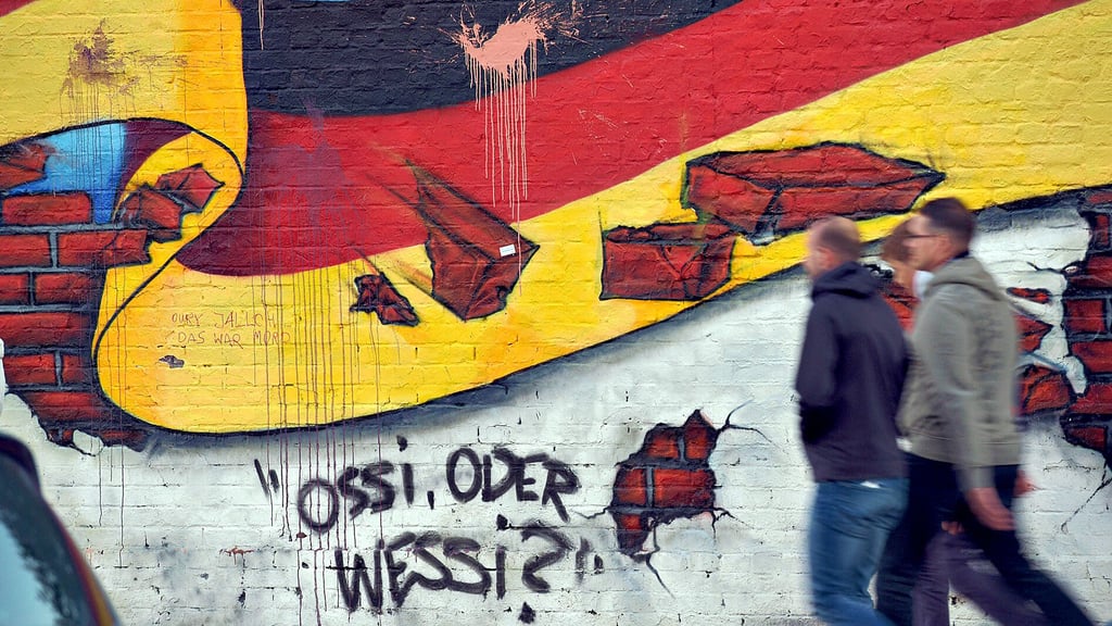 „Ossi oder Wessi“ – steht auf einem Stück der Berliner Mauer. Ist die Mauer im Kopf immer noch da? Auch bei den Nachwendekindern? Die Volksstimme fragte nach.