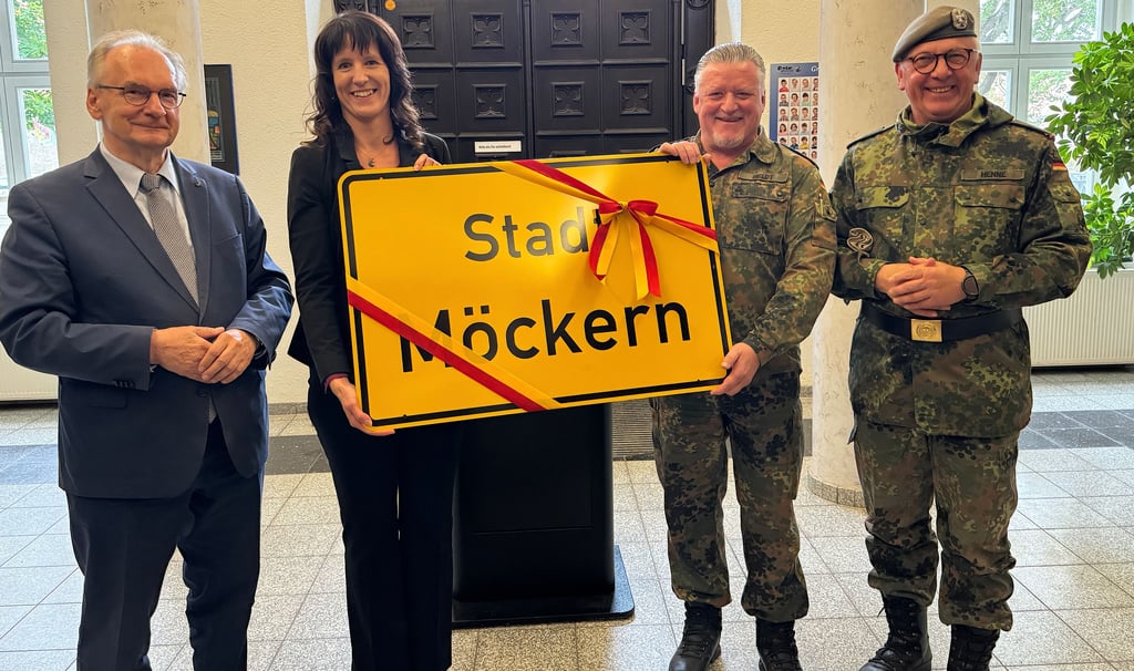 Im Beisein von Ministerpräsident Reiner Haseloff übergab Möckerns Stadtbürgermeisterin Doreen Krüger ein Ortsschild der Stadt Möckern an den Regimentskommandeur Carsten Heldt und Divisionskommandeur Andreas Henne (v. li.).