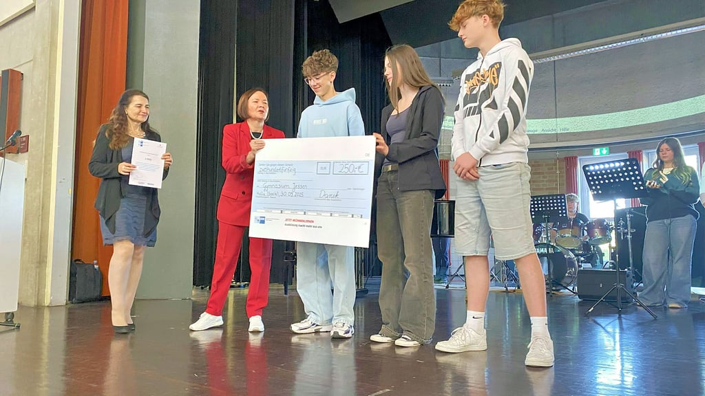 Simone Danek übergibt den symbolischen Scheck an Neo Schmale, Fiona Gräbner und Paul Obenaus. Marcella Mertig (li.) gratuliert ebenfalls.