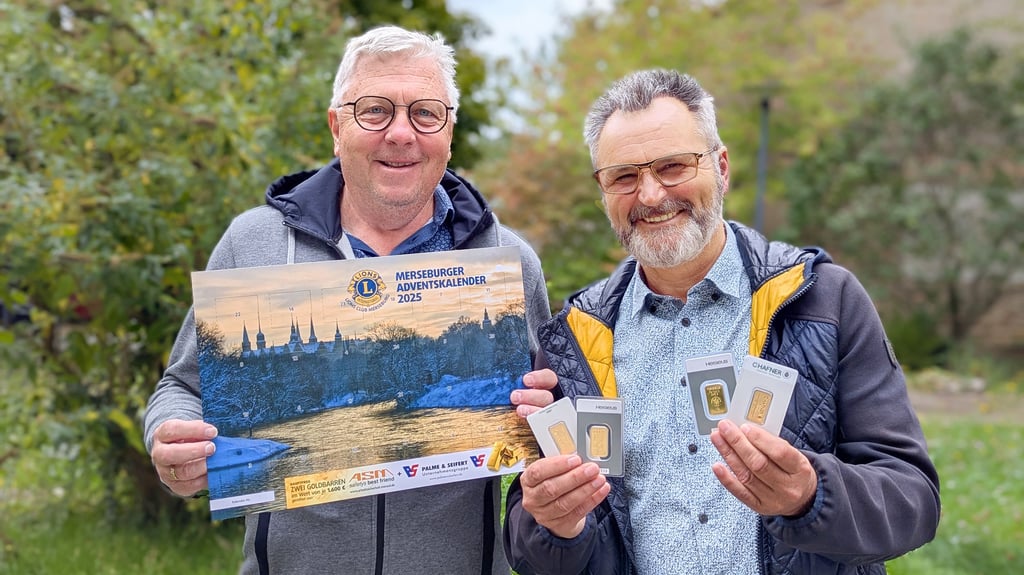 Roland Schwarz und Horst Naumann präsentieren den Adventskalender 2025 der Lions und die beiden Hauptgewinne in Form von je zwei Goldplättchen.