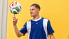 Florian Wirtz mit dem offiziellen WM-Spielball „Trionda“.