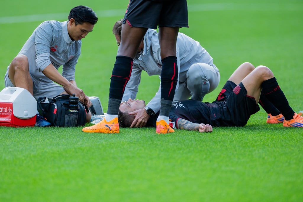 Bayer Leverkusens Kapitän Alejandro Grimaldo liegt nach einem Zusammenprall auf dem Boden.