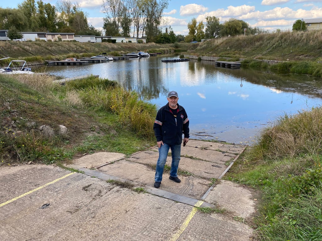 Ein Bild mit Symbolkraft: Wo sich die rechte Fußspitze von Vereinschef Jörg Wetzel befindet, müsste eigentlich das Wasser stehen, um den Normalbetrieb im Hafen zu gewährleisten. Doch der Vorsitzende des Wassersportvereins Buckau-Fermersleben in Magdeburg hat mit seinen Vereinsmitgliedern immer häufiger mit Niedrigwasser zu kämpfen.