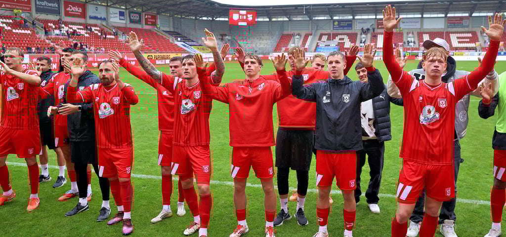 Die durchnässten HFC-Spieler feiern das 1:0 gegen den ZFC Meuselwitz.