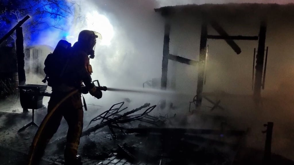 Ein Kamerad der Feuer löscht die letzten Flammen am Freitagmorgen.