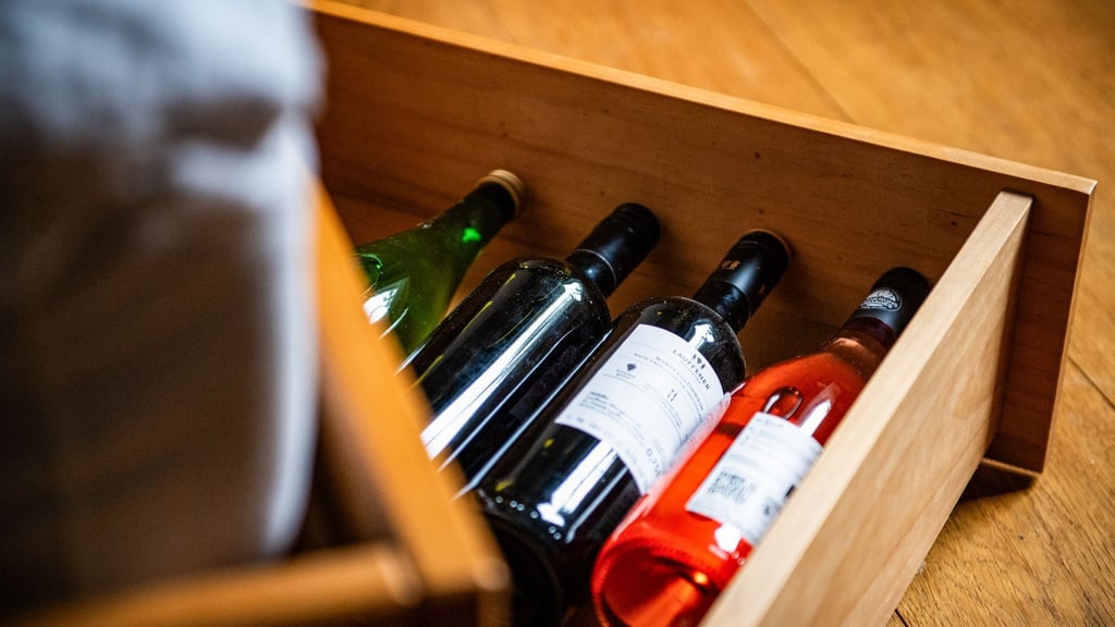 Da liegen sie gut: Weinflaschen lagern in einem Bettkasten im Schlafzimmer - ohne große Temperaturschwankungen.