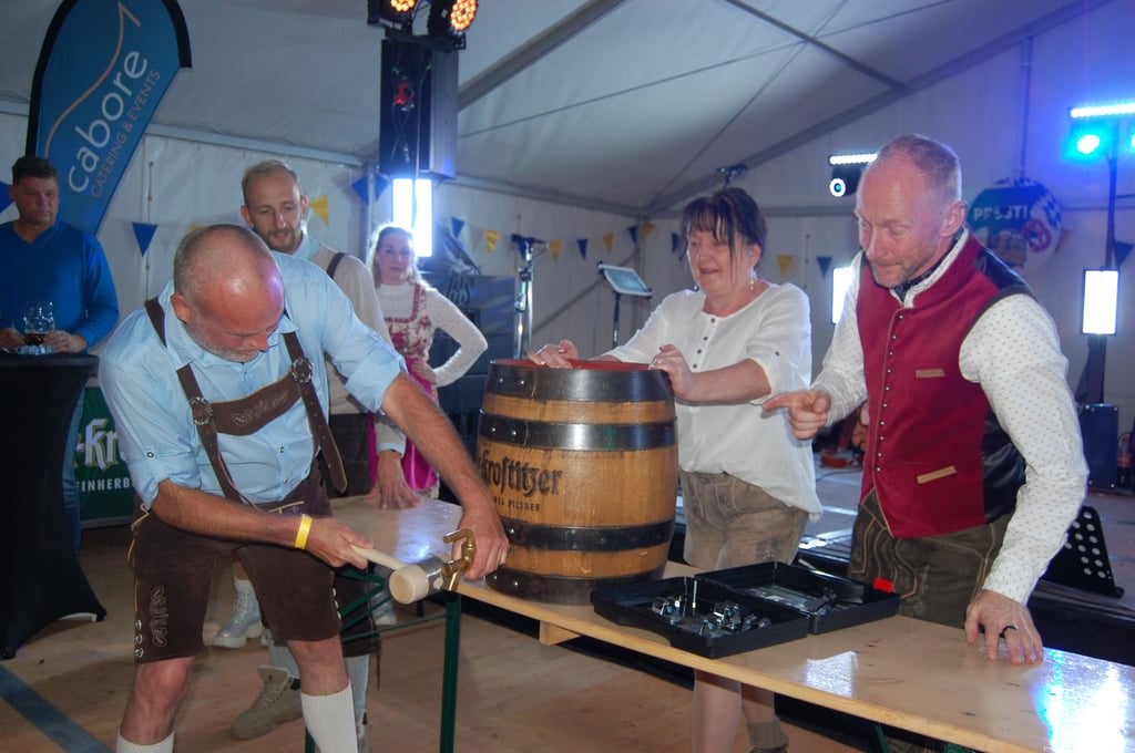Bierkrieger“ Mario Zinke (v. l.) sticht mit Unterstützung von seiner Frau Manja und Wirt Heiko Frischleder ein Fass Freibier an.
