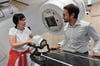 Die Leitende Radiologin Sabine Hartwig und Klinikdirektor Daniel Medenwald erläutern die Funktionsweise des Bestrahlungsgeräts an einem Torso.