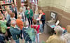 Wie Bücher der Hochschulbibliothek ausgeliehen werden können, erklärt Mitarbeiter Sven Weinhauer (Mitte) den Besuchern. 