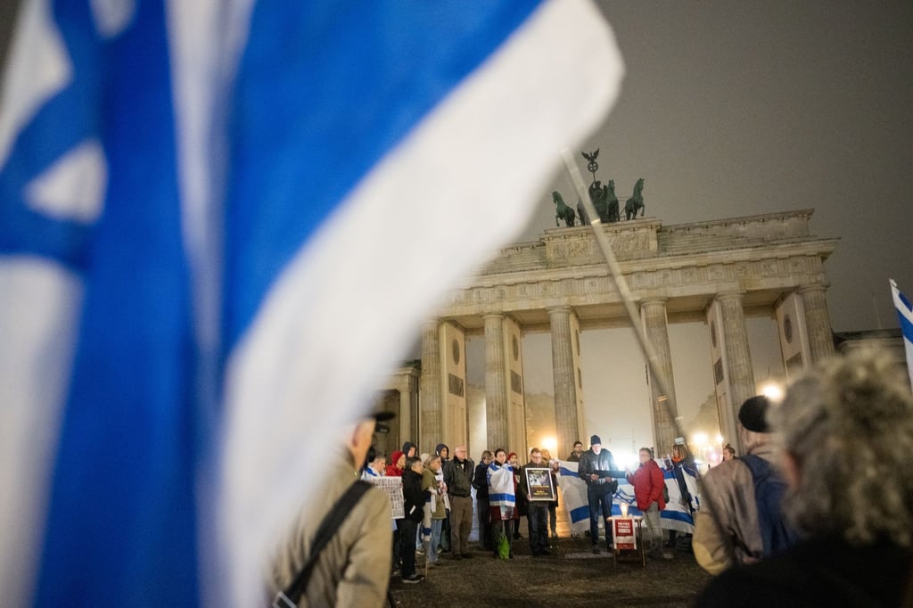 Menschen erinnern am Brandenburger Tor an die Opfer des 7. Oktober.