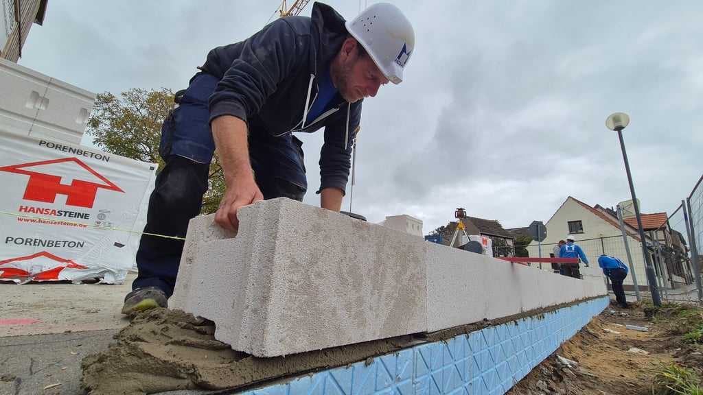 Maurer Stephan Rachowski vom Stendaler Unternehmen Mebag platzier einen rund 25 Kilo schweren Stein aus Porenbeton auf der Baustelle an der sogenannten Spatzenfalle in Arneburg.