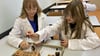 Tamara (links) und Sophia wollen beim Tag der offenen Tür an der Seelandschule herausfinden, ob Gummibären sauer oder basisch sind. 