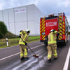 Die Einsatzkräfte der Feuerwehr Burg entfernen Rückstände einer Ölspur nahe des Gewerbegebietes.