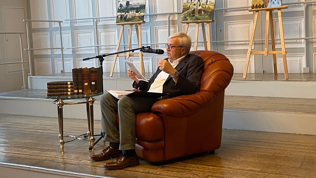 Rüdiger Schülbe liest aus den Momenten der Schulgeschichte vor.