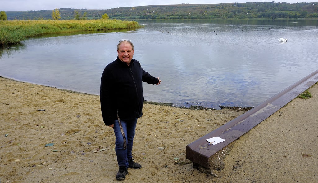 Ralf Leberecht verweist auf das glasklare Wasser an der Badestelle samt gepflegtem Sandstrand.
