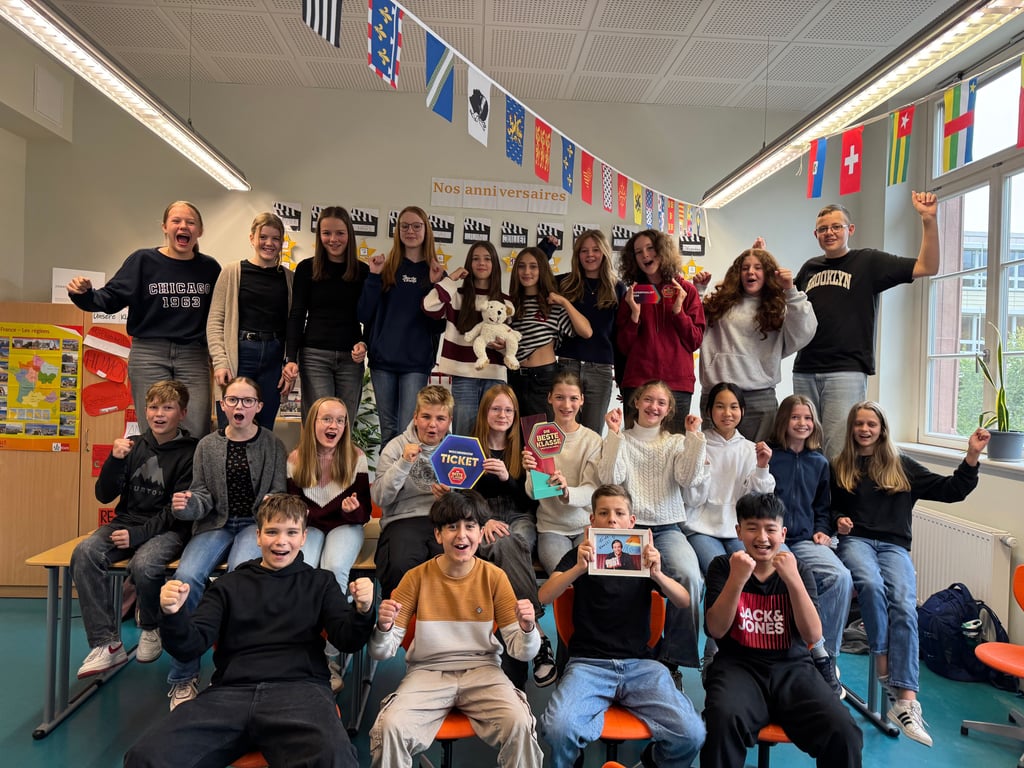 Die 7/2 (ehemals 6/2) feiert im Klassenraum mit Pokal und Maskottchen.