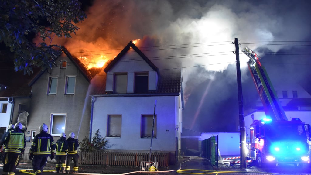 Die Feuerwehrleute bekämpfen die Flammen – ein Übergreifen auf benachbarte Häuser kann jedoch nicht verhindert werden.