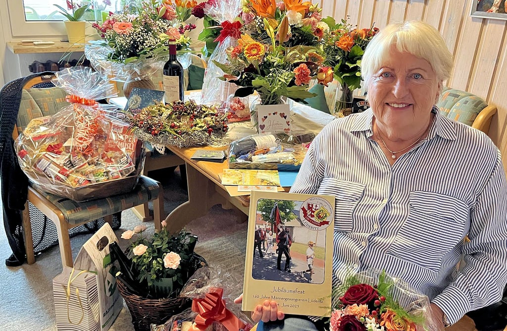 Edith Braun in einem Raum voll Blumen und Glückwünsche. Zu den Überraschungen gehörte unter anderem ein Buch des Lüderitzer Männergesangsvereins, für den sich die Ortsbürgermeisterin von Lüderitz, wie für alle Vereine im Ort, stark macht.