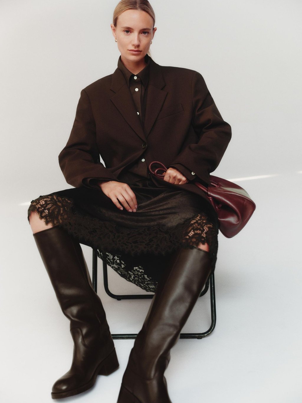 All-Brown-Styling: Schokobraun in verschiedenen Nuancen schafft Tiefe und Eleganz im monochromen Look, hier von Arket (Hemd ca. 89 Euro, Blazer ca. 169 Euro, Satinrock mit Spitze ca. 89 Euro, Stiefel ca. 299 Euro, Tasche ca. 149 Euro).