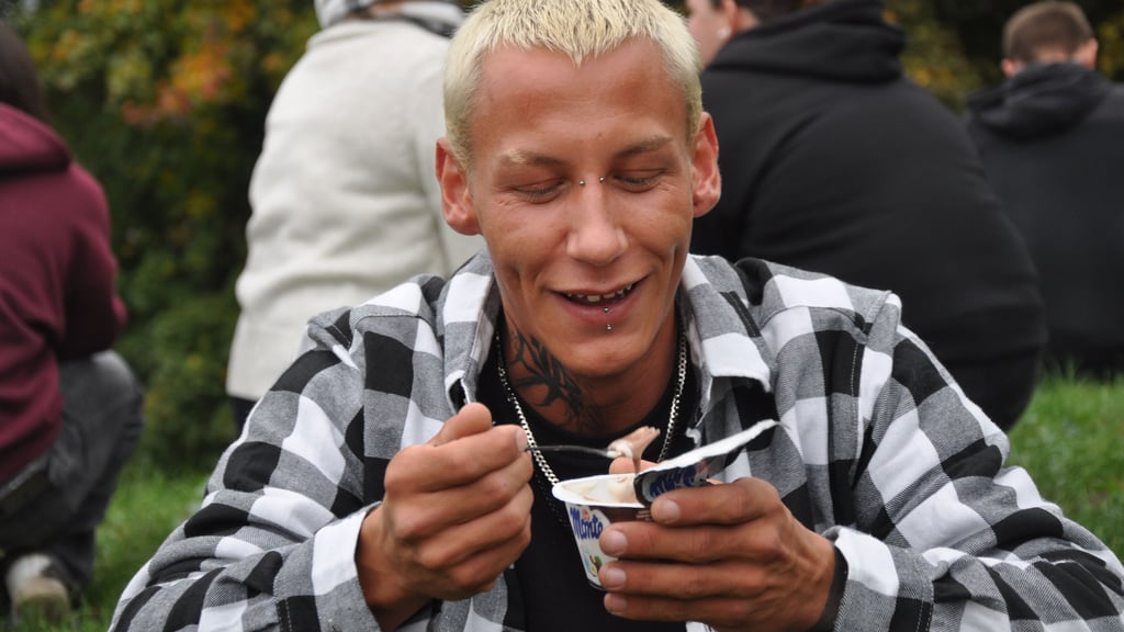 Tom Reichenbach isst am Schwanenteich in Stendal einen Pudding mit einer Gabel.
