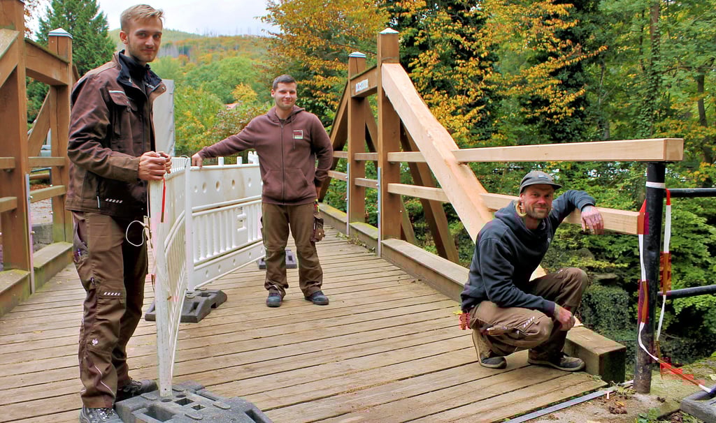 Kevin Sielaff, Julien Olbert und Fabian Kath (von links) von der Tischlerei Reinecke aus Ilsenburg sperren nach getaner Reparatur einen Teil der Blochhauer-Brücke wieder ab.