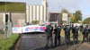 Mit einer Sitzblockade protestieren Aktivisten vor der Zufahrt eines Hafendienstleisters in Bremen-Walle.